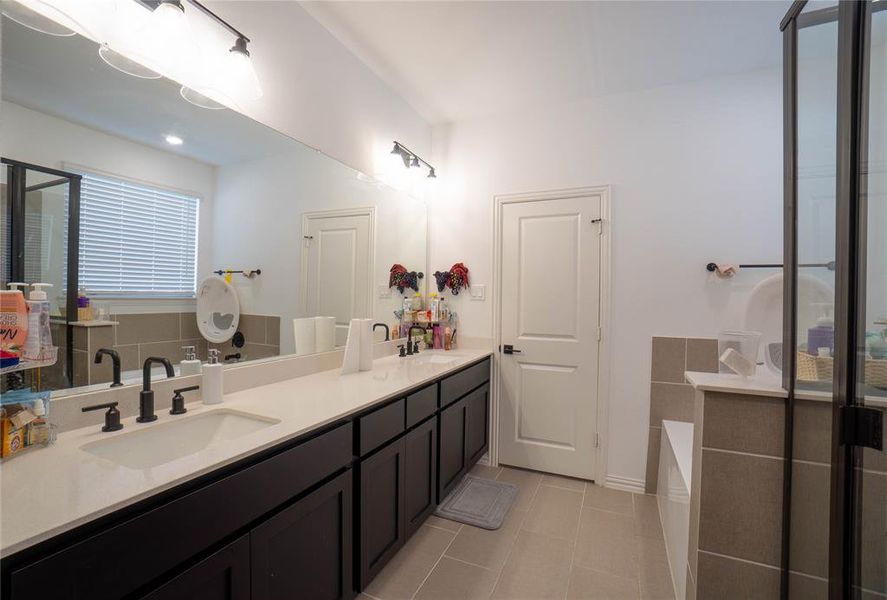 Double vanity with integrated sinks, quartz countertop, and matte black fixtures