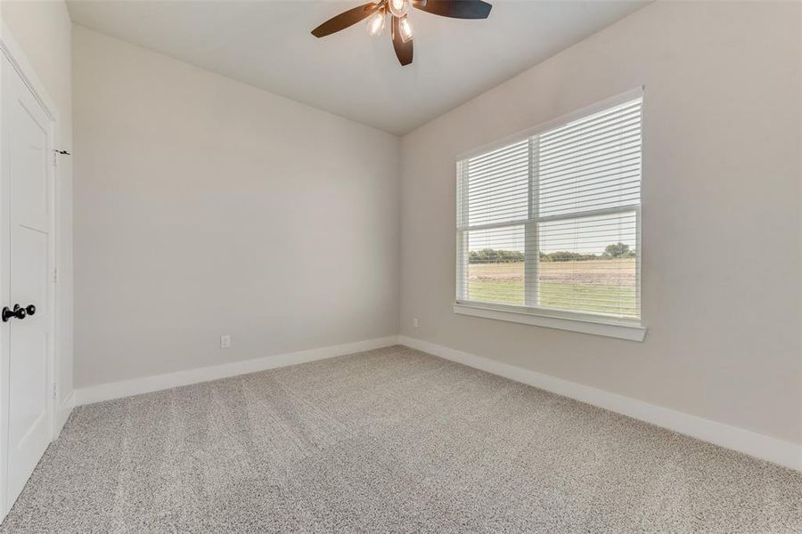 Carpeted spare room with ceiling fan