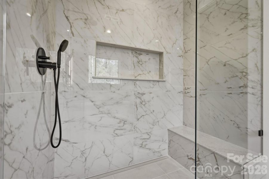 The luxurious zero entry walk-in shower is fabulous and is custom tiled with an upgraded custom frameless glass shower wall, niche and bench. The luxurious zero entry walk-in shower is fabulous and is custom tiled with an upgraded custom frameless glass shower wall, niche and bench.