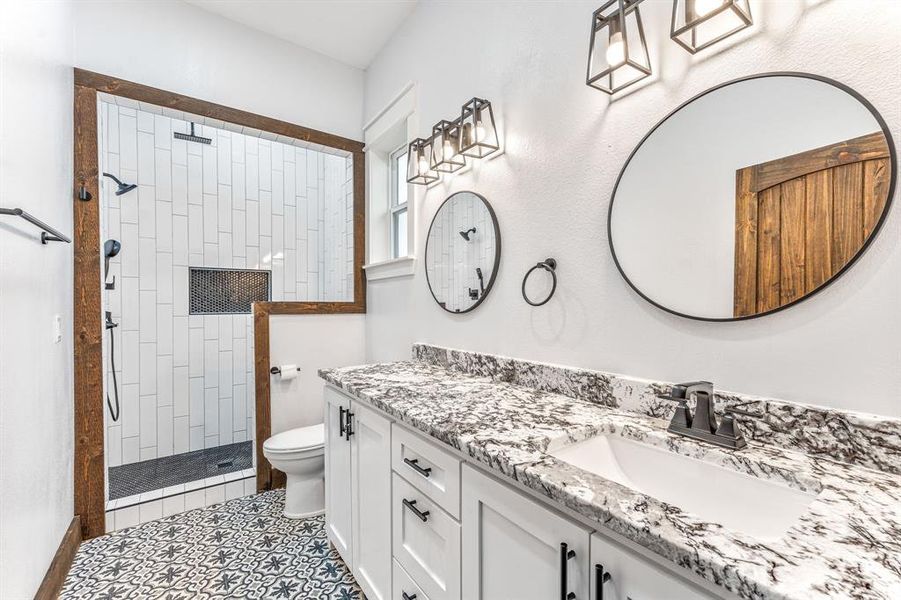 Bathroom with walk in shower, vanity, and light tile patterned floors