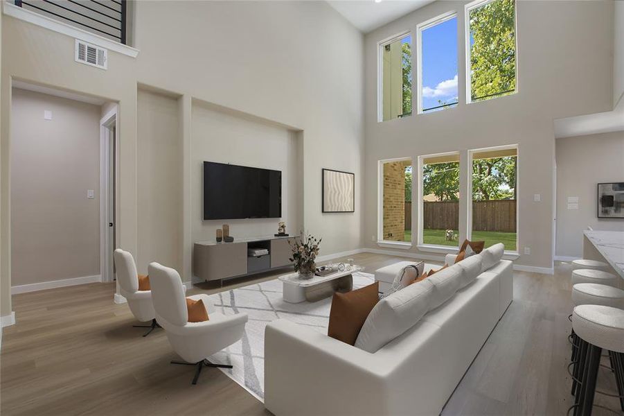 Living room featuring light wood-type flooring and a high ceiling