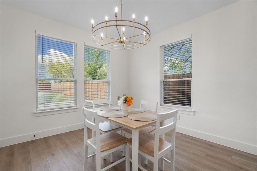 Dining room with healthy amount of natural light, light wood finished floors, and a chandelier Dining room with healthy amount of natural light, light wood finished floors, and a chandelier
