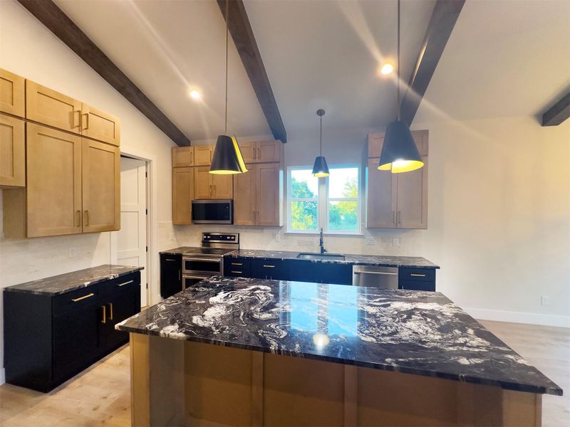 Striking stone countertops and exposed ceiling beams define this contemporary culinary space. Striking stone countertops and exposed ceiling beams define this contemporary culinary space.
