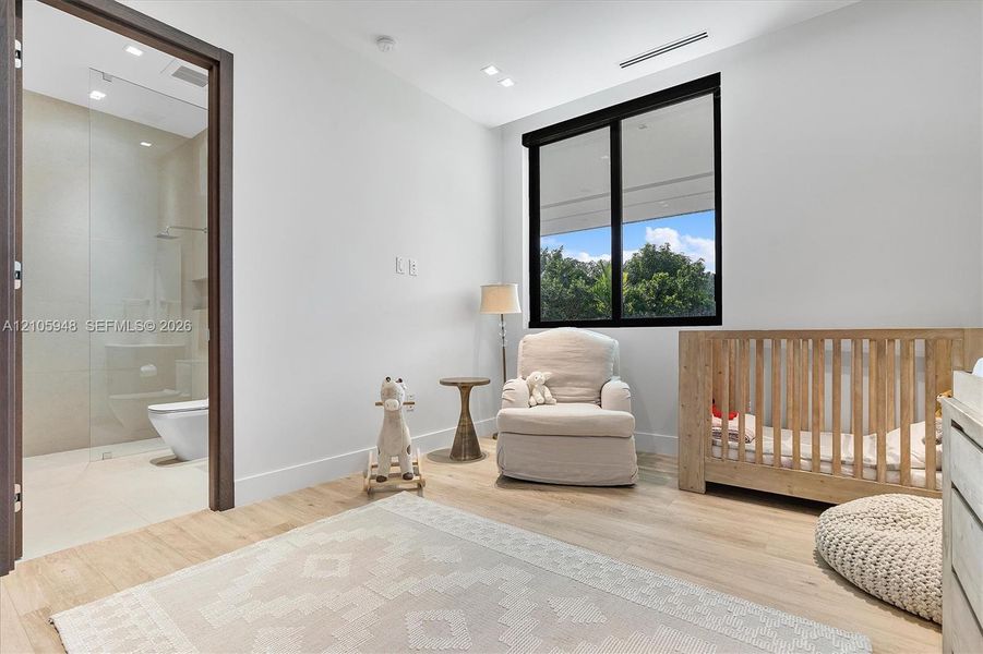 Light-filled room featuring wood-finish flooring, recessed lighting, and a window with a black frame
