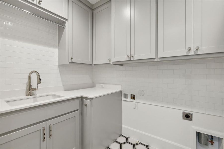 Laundry area featuring cabinets, hookup for an electric dryer, washer hookup, sink, and hookup for a gas dryer