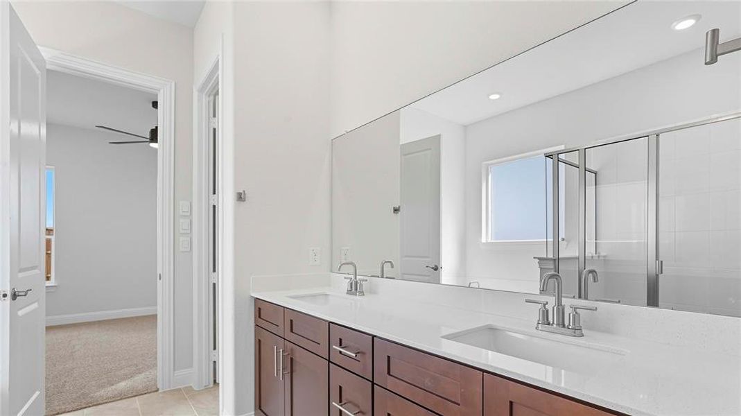 Full bath with double vanity, a stall shower, light colored carpet, and light tile patterned flooring