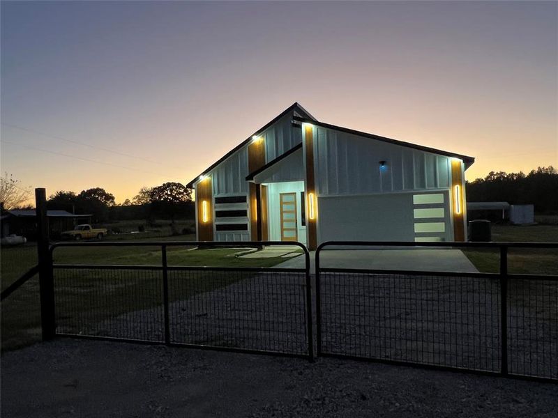 View of front of home featuring a garage, a fenced front yard, and driveway View of front of home featuring a garage, a fenced front yard, and driveway