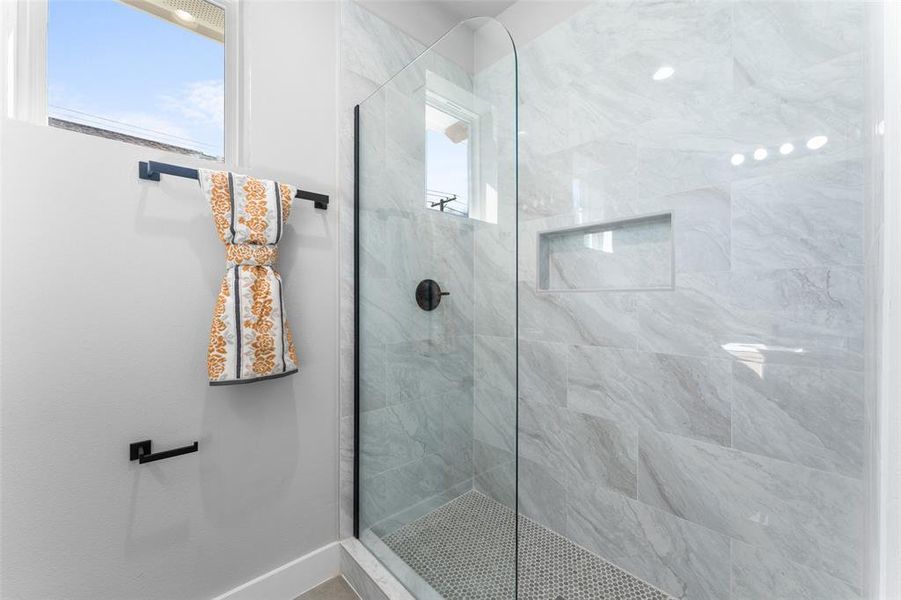Bathroom with a stall shower and healthy amount of natural light