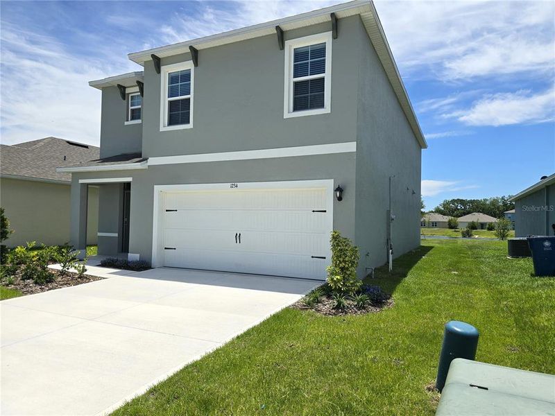 Front exterior of a new home in Charles Cove Express, Davenport, FL, highlighting curb appeal (Image 16).