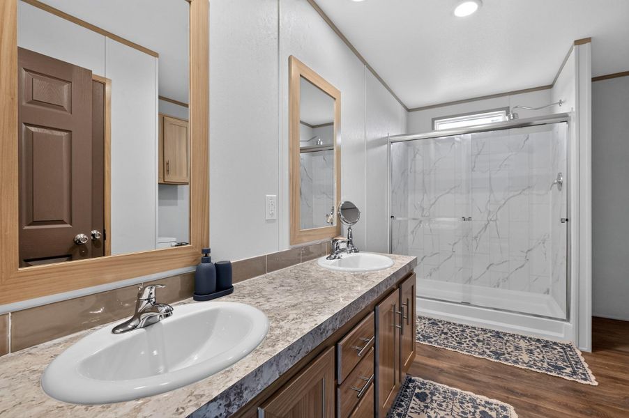 Double vanity and a spacious shower create a serene and practical bathroom environment.