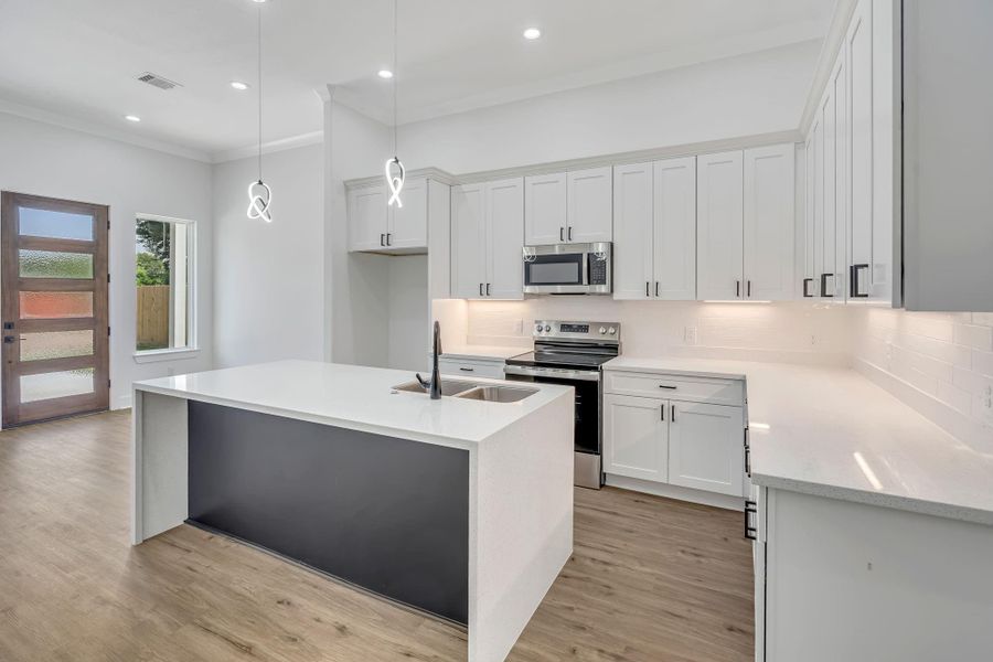 Modern kitchen featuring sleek under-cabinet lighting that highlights the quartz countertops and backsplash while providing both ambiance and functional task lighting.