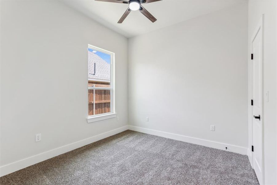 Carpeted spare room with ceiling fan