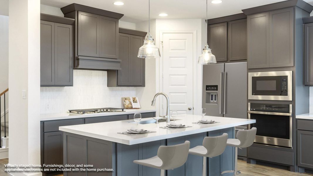 Kitchen featuring stainless steel appliances, a sink, light countertops, light wood-style flooring, and recessed lighting Kitchen featuring stainless steel appliances, a sink, light countertops, light wood-style flooring, and recessed lighting