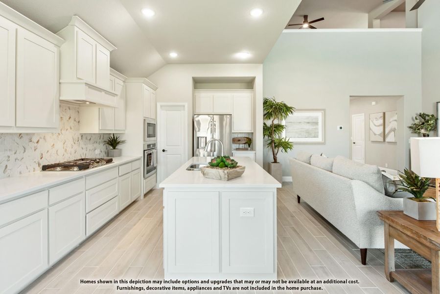 Open-concept kitchen with white cabinets, center island, and stainless appliances flowing into living area Open-concept kitchen with white cabinets, center island, and stainless appliances flowing into living area
