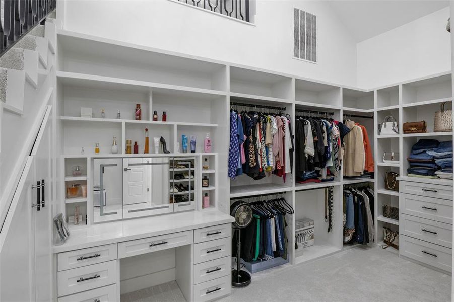 Spacious closet with vaulted ceiling and light colored carpet Spacious closet with vaulted ceiling and light colored carpet