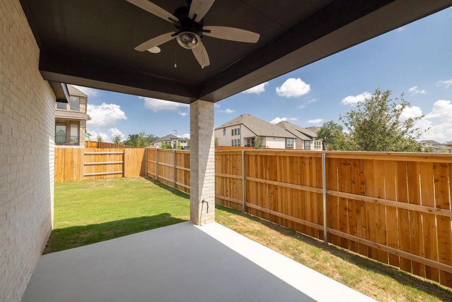 Fenced backyard with a patio, ceiling fan, and a residential view Fenced backyard with a patio, ceiling fan, and a residential view