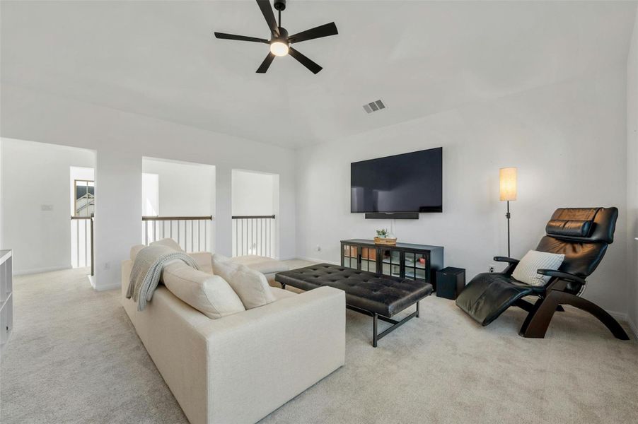 Ascend the open stairway to find a sizable bonus living area with vaulted ceilings and a modern LED ceiling fan.