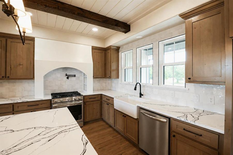 Kitchen featuring a white farmhouse sink, wood-finish cabinetry, and white countertops