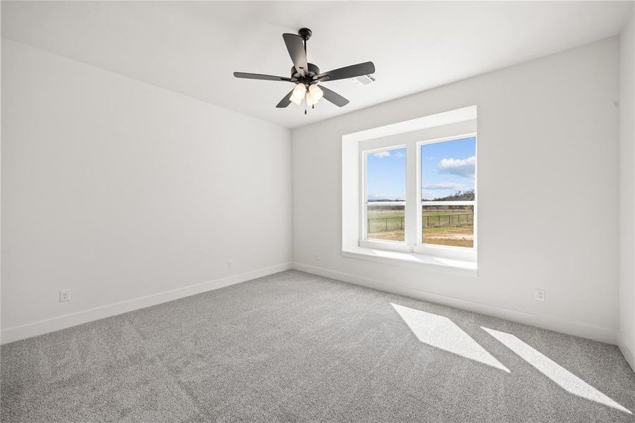 Spare room featuring light carpet and a ceiling fan