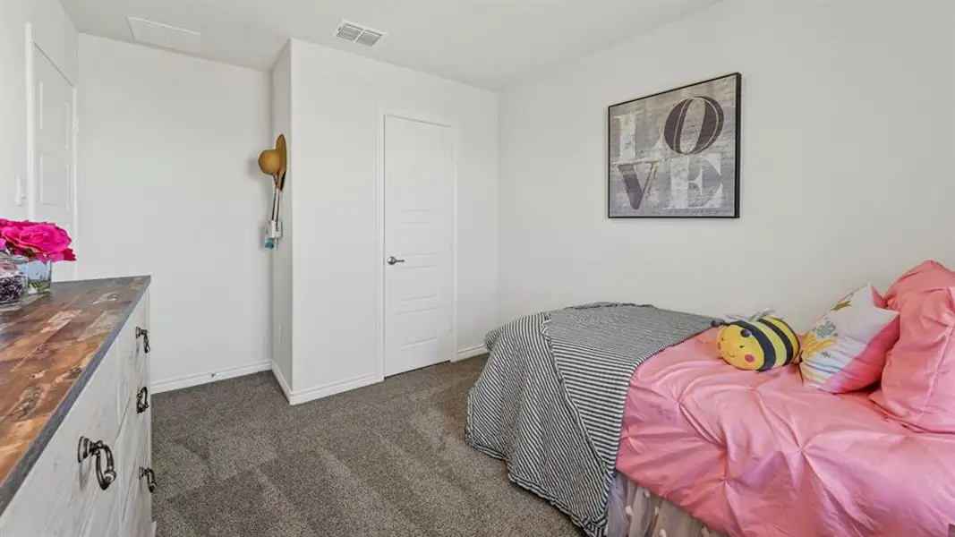 Neutral wall paint, gray carpet flooring, and a white interior door with panel detailing