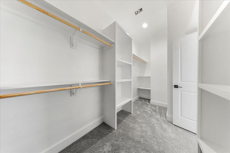 Spacious closet featuring light colored carpet Spacious closet featuring light colored carpet