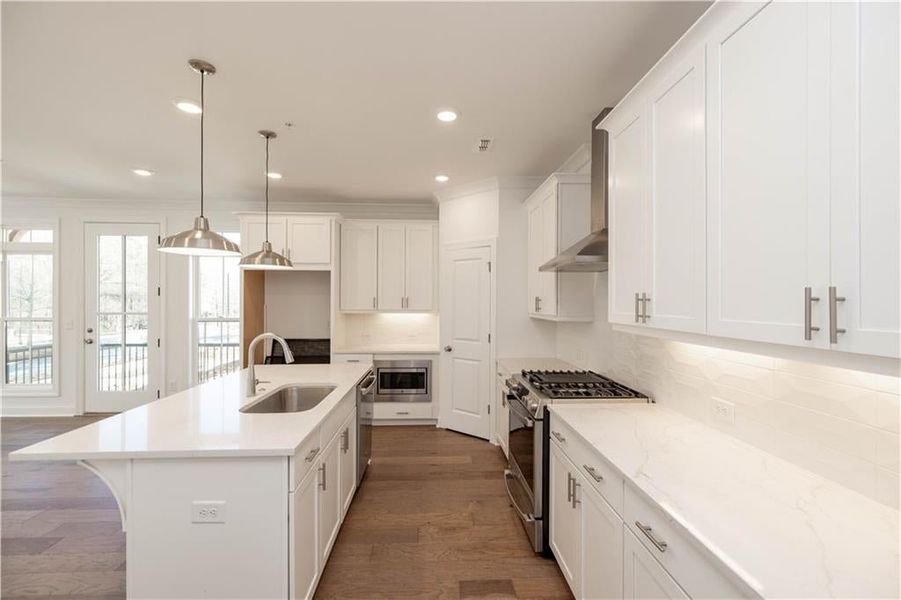As you reach the top of stairs, you enter into a gorgeous kitchen with bright white cabinets and quartz countertops.