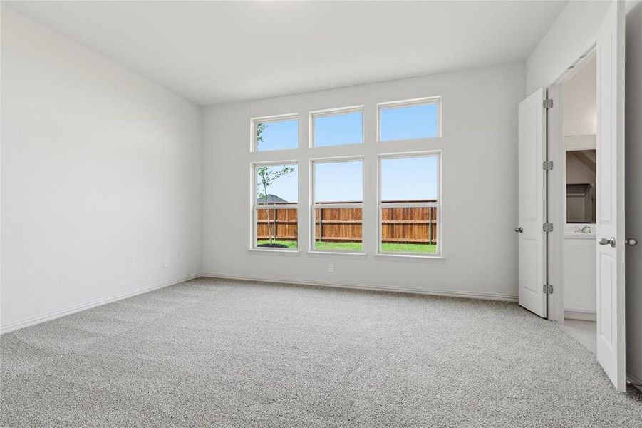 Spare room featuring light colored carpet and baseboards