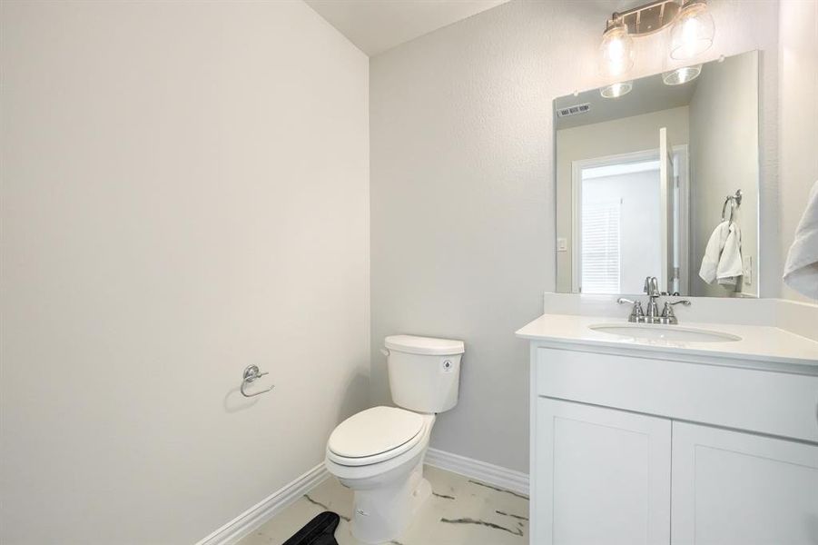 Half bathroom featuring baseboards and vanity Half bathroom featuring baseboards and vanity
