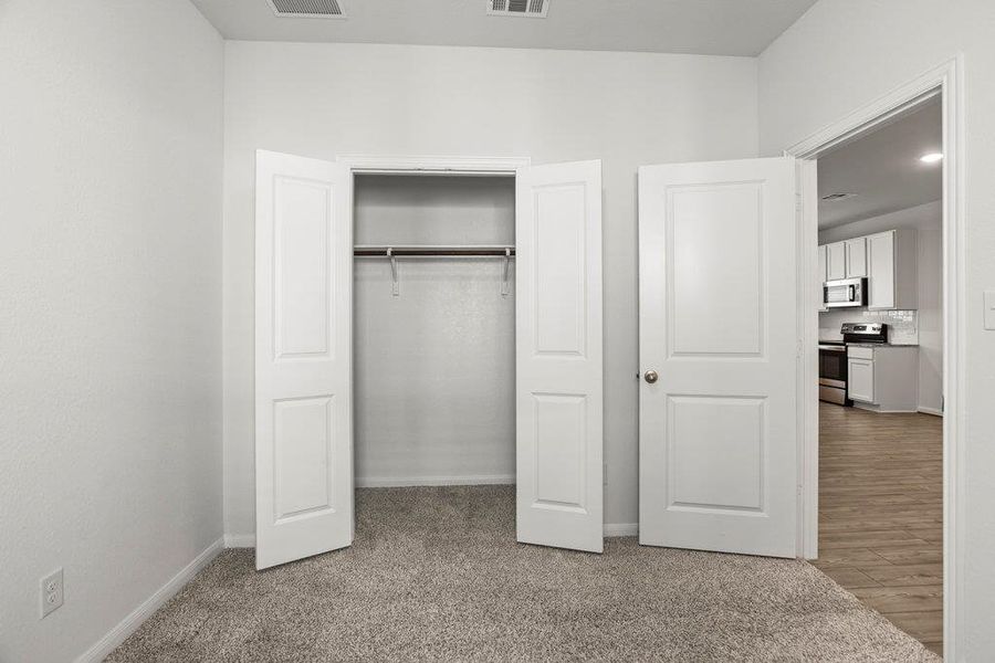 Unfurnished bedroom with light carpet and a closet