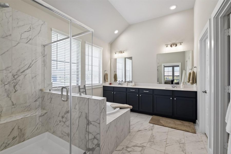 The primary en-suite bath features a large walk-in shower, deep soaking tub and his & her sinks.