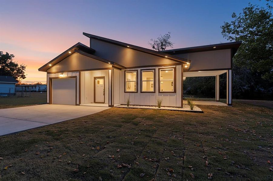 Contemporary home with a front lawn, driveway, an attached garage, and a patio area Contemporary home with a front lawn, driveway, an attached garage, and a patio area
