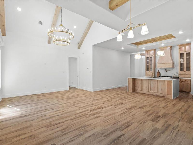Kitchen featuring glass insert cabinets, open floor plan, recessed lighting, light wood-style flooring, and decorative backsplash