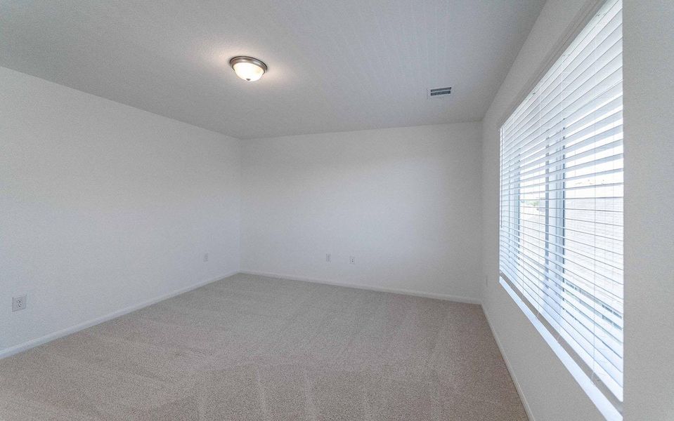 Empty room featuring light carpet and baseboards Empty room featuring light carpet and baseboards