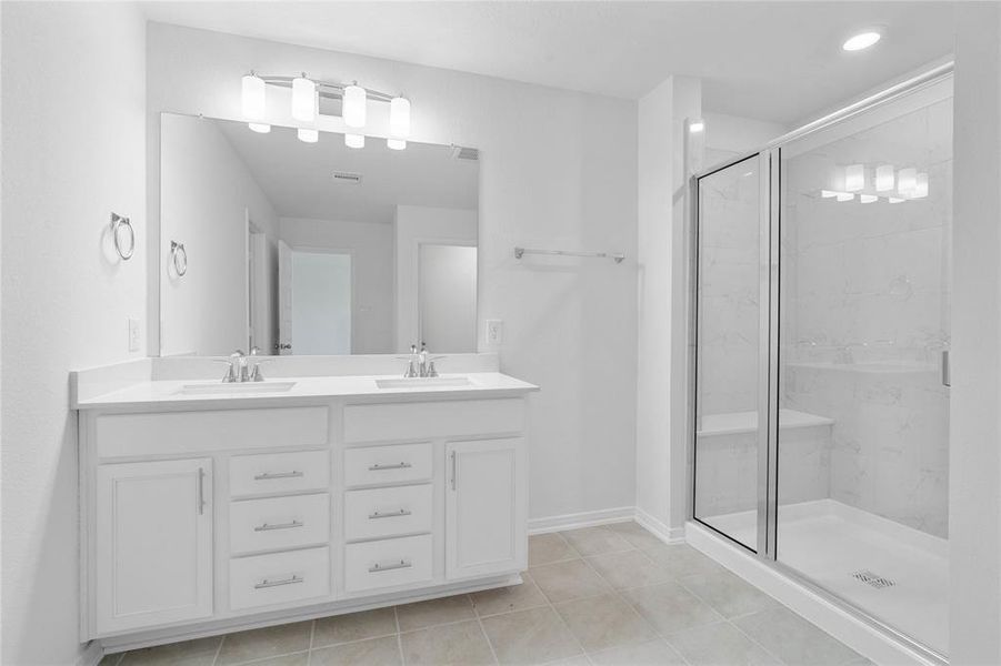 This primary bathroom is definitely move-in ready! Featuring an oversized walk-in shower with tile surround and seat, stained cabinets with light countertops, dual vanities, high ceilings, neutral paint, sleek and modern finishes.