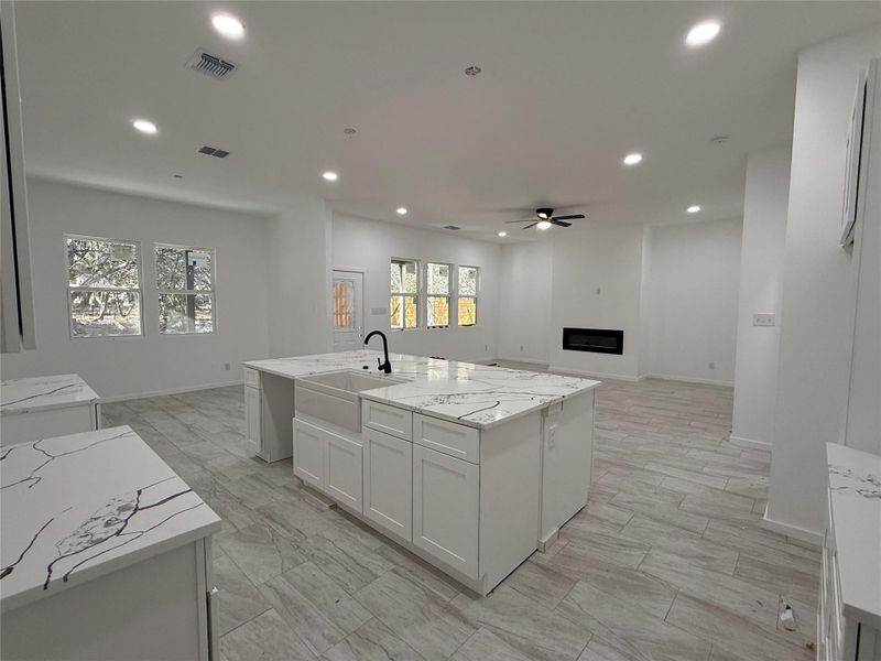 Kitchen with views of living area with electric fireplace