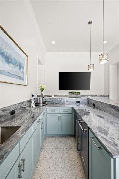 Kitchen featuring crown molding, stone countertops, light flooring, decorative light fixtures, and recessed lighting Kitchen featuring crown molding, stone countertops, light flooring, decorative light fixtures, and recessed lighting