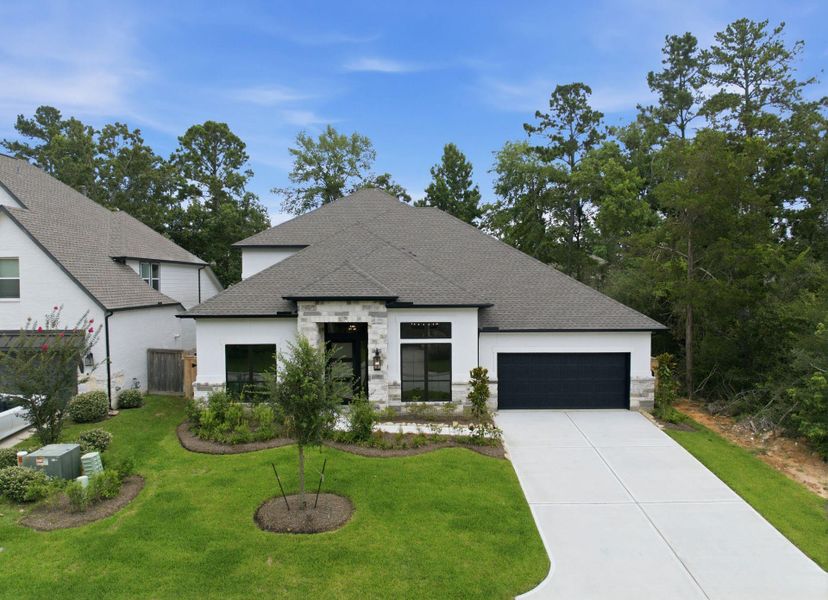 Front exterior of a new home in The Woodlands Hills 65′, Willis, TX, highlighting curb appeal (Image 1). Front exterior of a new home in The Woodlands Hills 65′, Willis, TX, highlighting curb appeal (Image 1).