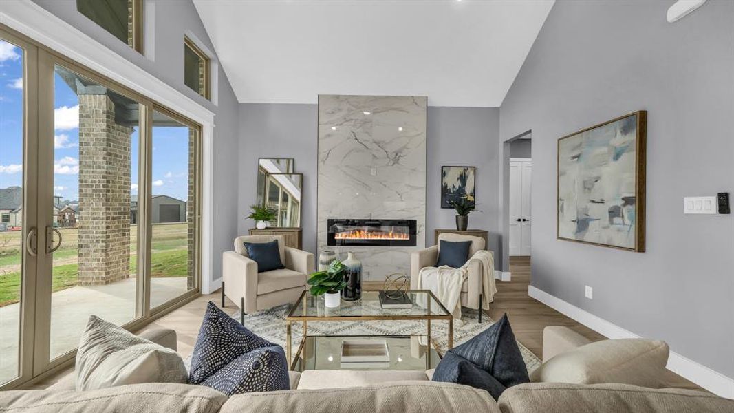 Living area with a fireplace, high vaulted ceiling, and wood finished floors