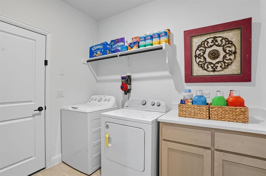 Laundry room featuring washer and clothes dryer and light tile patterned flooring