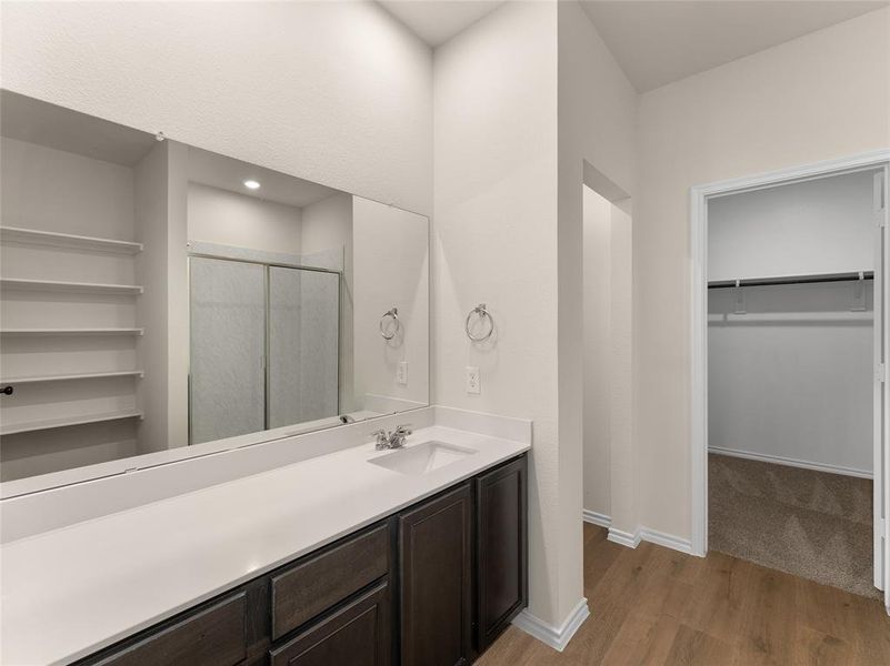 Bathroom featuring walk in shower, wood-type flooring, and vanity