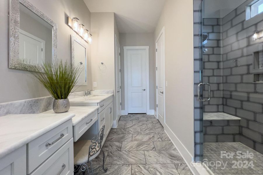 Indulge in luxury with a custom extended shower featuring ombre tile that transitions seamlessly from light to dark, creating a stunning visual effect.