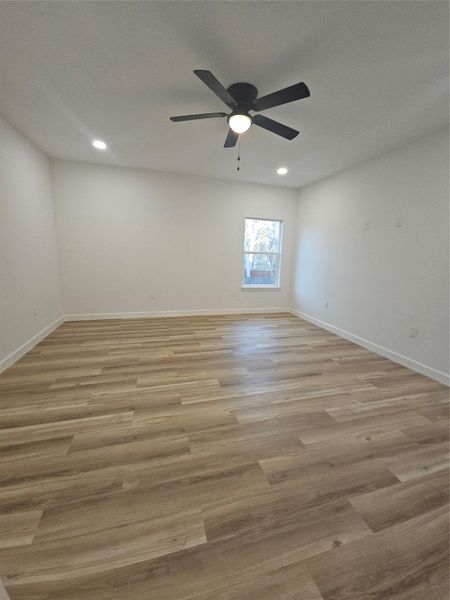 Spare room with a ceiling fan, recessed lighting, light wood-style floors, and baseboards