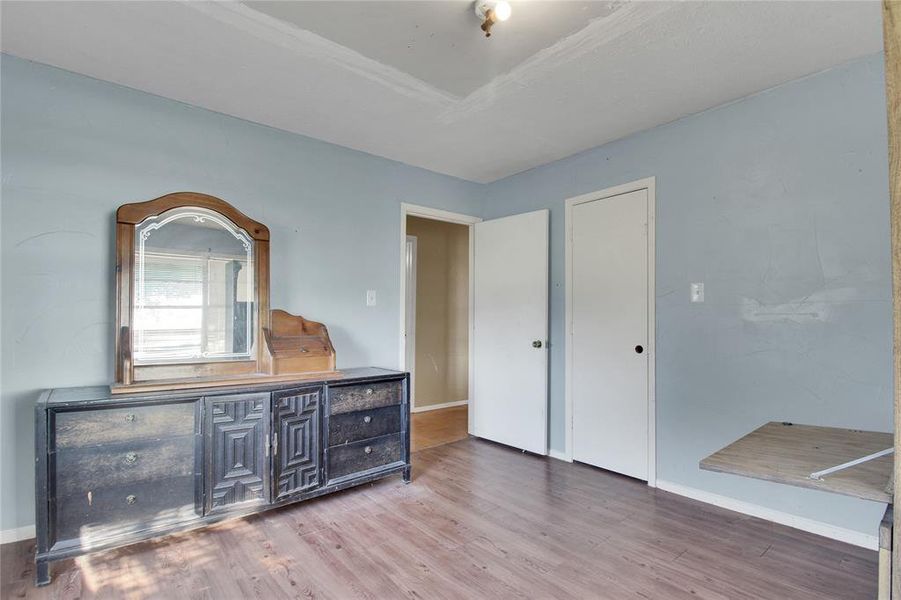 Unfurnished bedroom featuring wood finished floors and baseboards Unfurnished bedroom featuring wood finished floors and baseboards