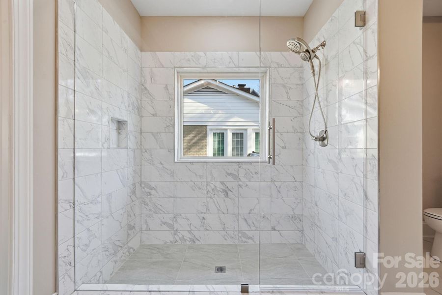 Walk-in shower with seamless glass enclosure and upscale tile work. Walk-in shower with seamless glass enclosure and upscale tile work.