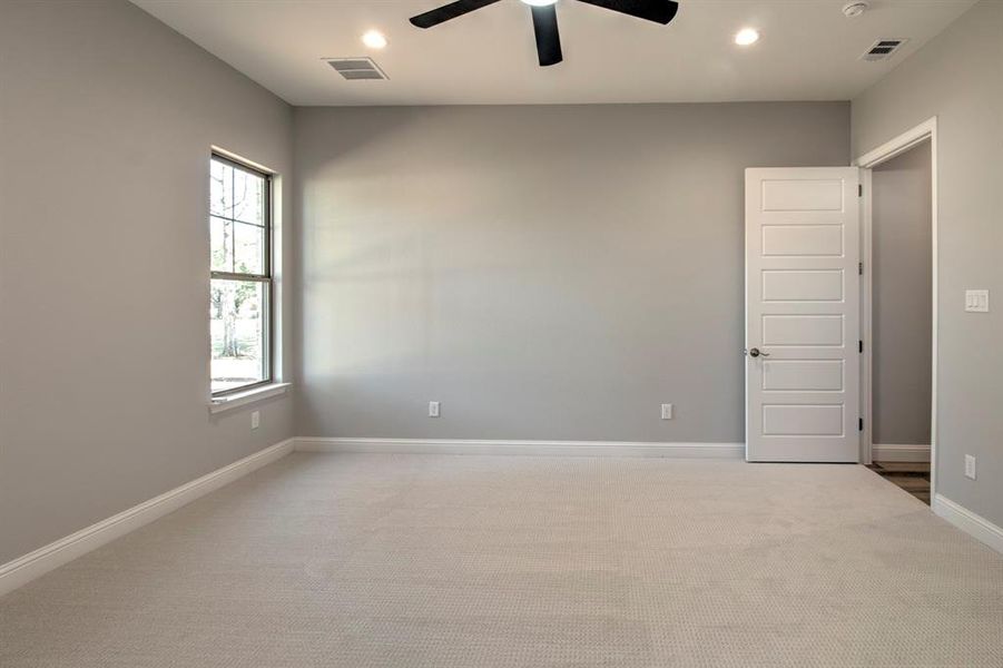 Carpeted empty room with ceiling fan