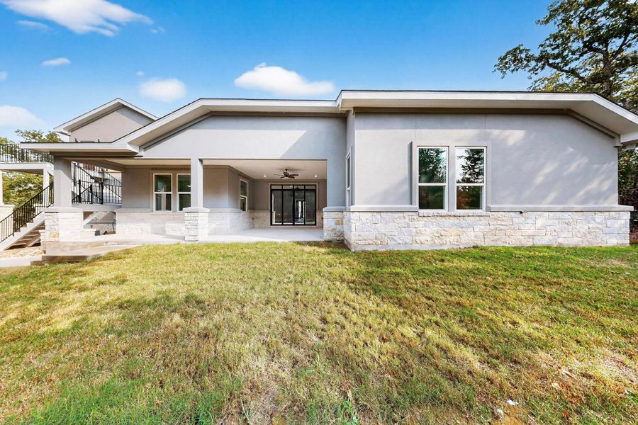 Back of property featuring half stucco, half masonry, lawn, and covered patio Back of property featuring half stucco, half masonry, lawn, and covered patio