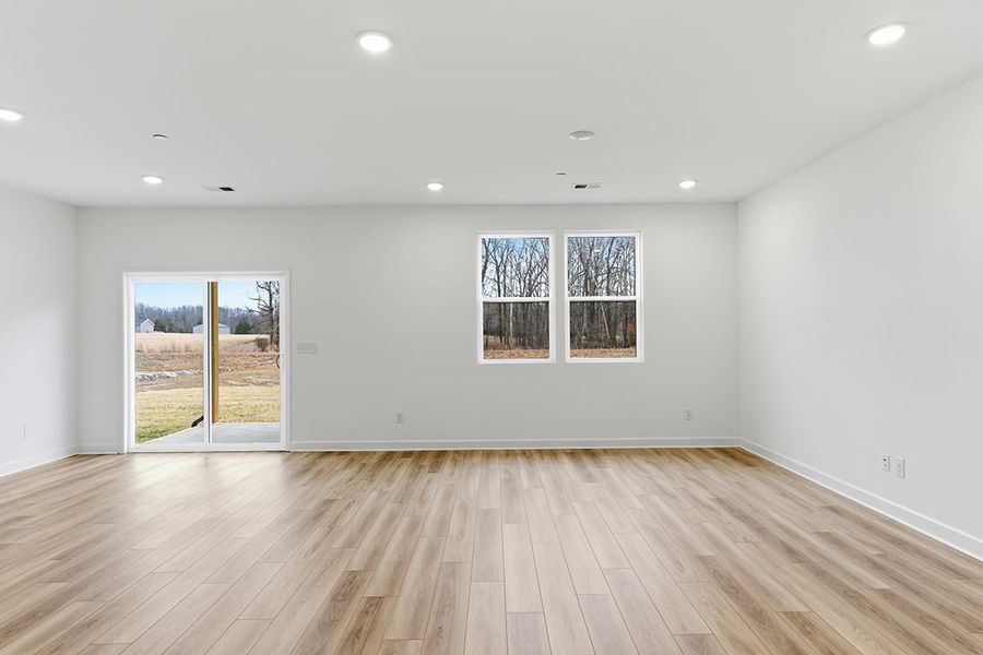 A room with a wood floor and windows.