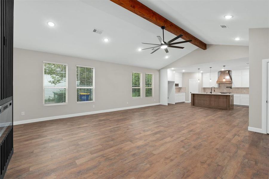 Unfurnished living room featuring dark wood-style flooring, a ceiling fan, and recessed lighting