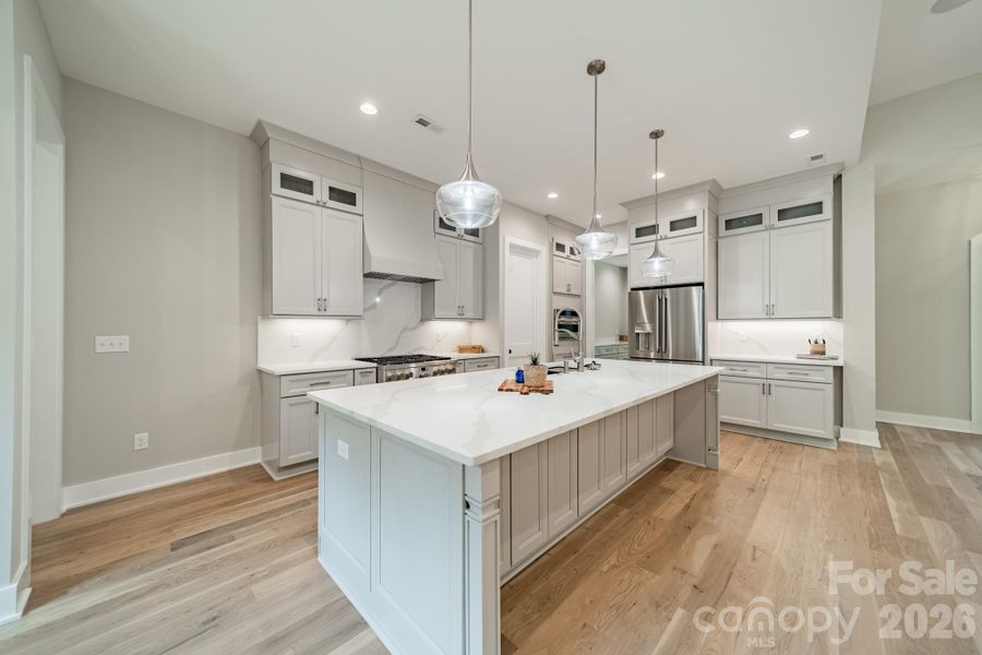 Fabulous Chef's Kitchen with oversized Gas Range and Oven, Quartz Counter Tops and Backsplash, and Custom Cabinetry