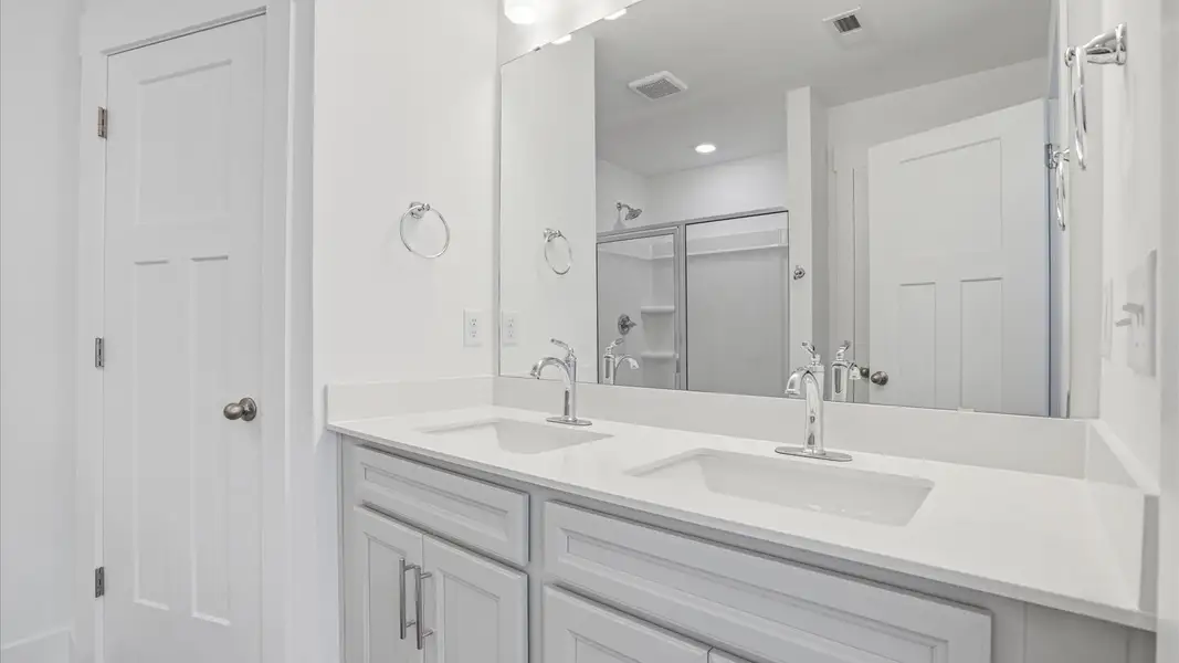 Notable primary bath featuring dual vanity, walk-in shower, and tasteful design touches throughout located at Marion Square